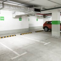 Underground car parking, empty modern parking lot indoor. Inside light parking garage in mall basement. istockphoto 1354491460 612x612